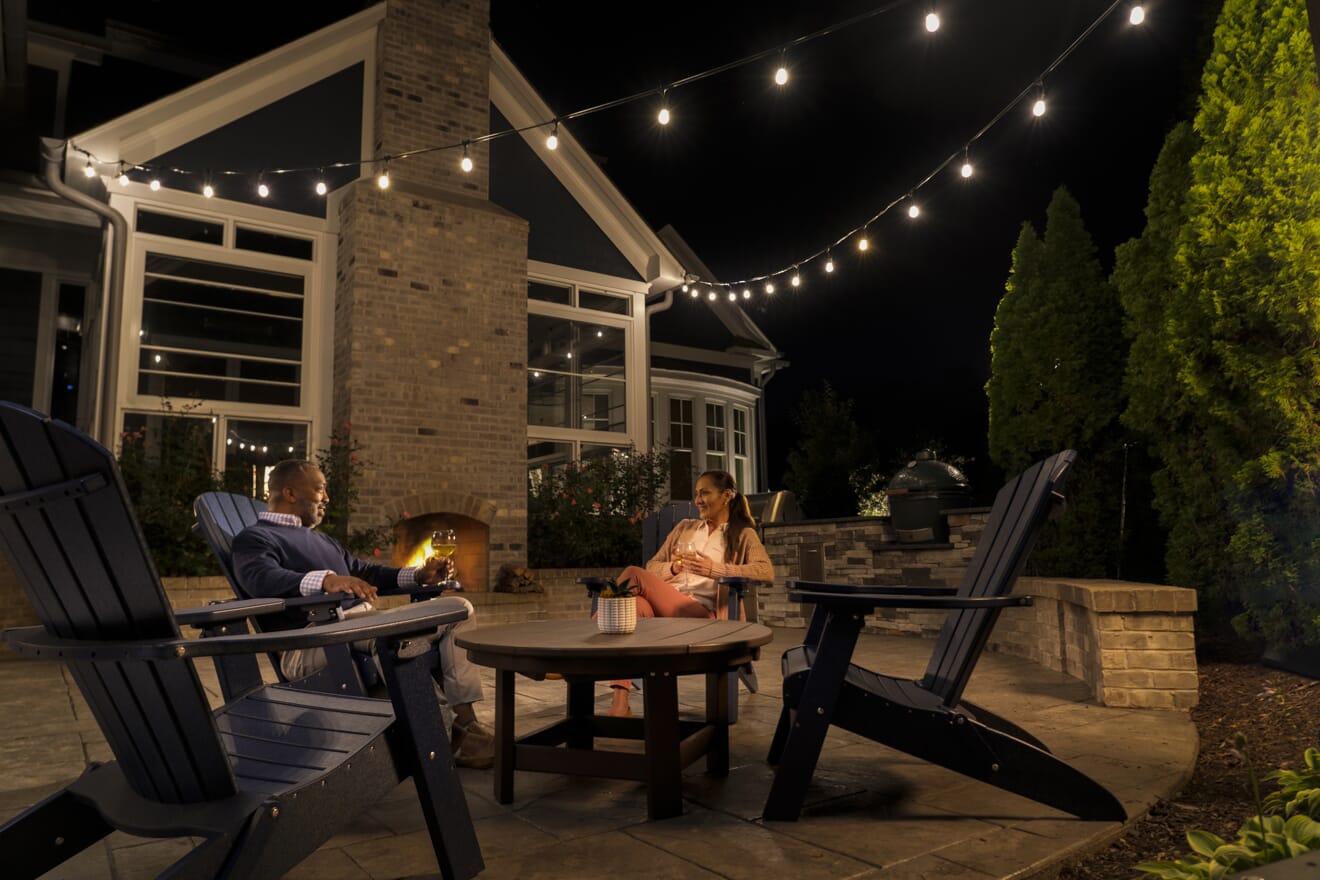 people sitting on patio with string lights